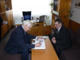 Deputy prime minister Rudolf Chmel signs the annals of the Secondary Grammar School in Handlov.